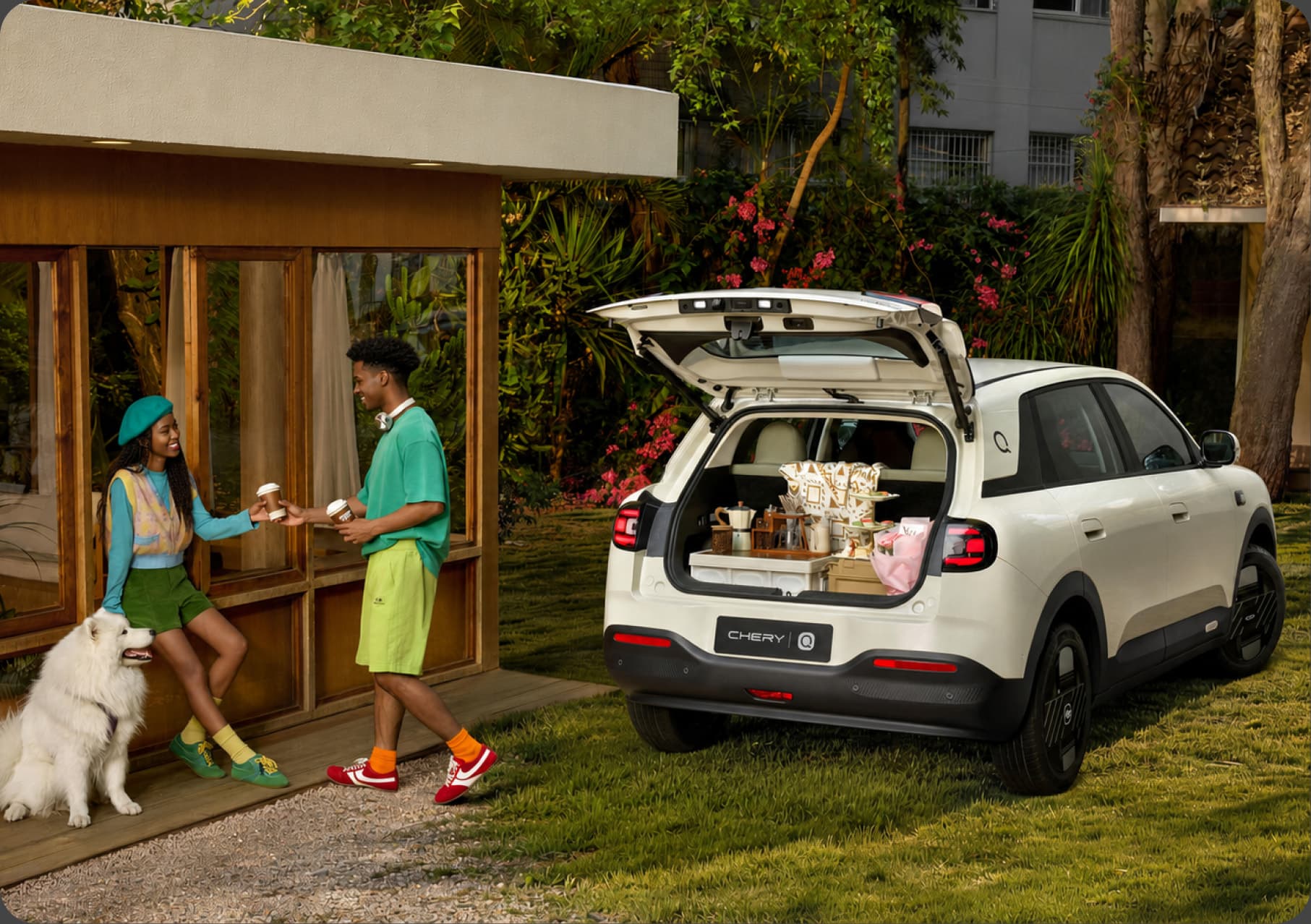 Chery Q with the hatch open on a lawn beside a cabin, packed for a picnic